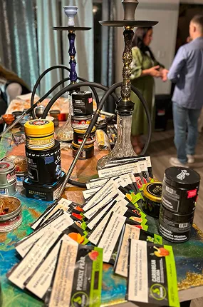 Table with premium hookah tobacco jars, flavor cards and prepared hookahs at a private event in NYC